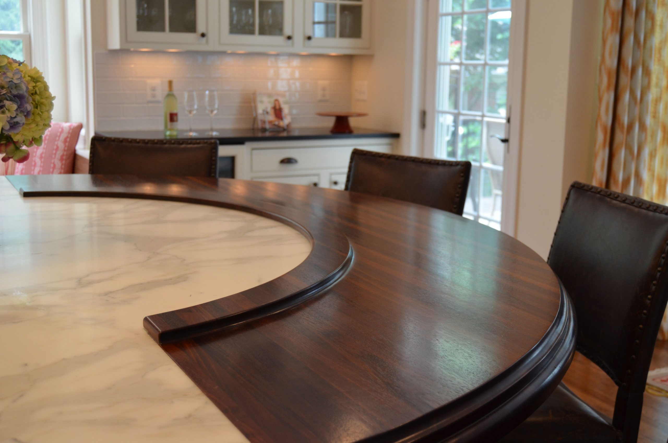 Walnut eating surface, and carrera marble worksurface make for an elegant wine tasting space while the hostess prepares dinner.